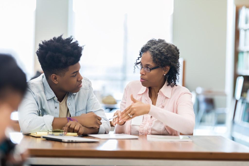 Coach en séance avec un jeune, autour d'une table de travail